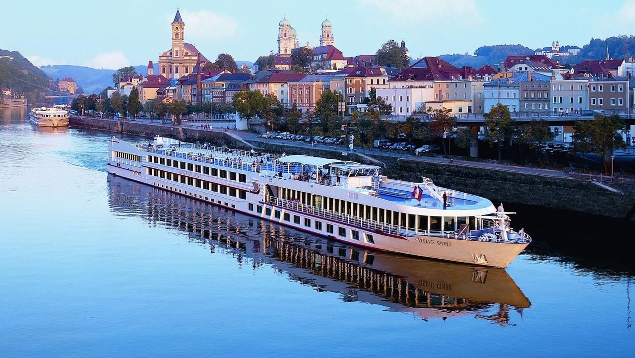 River cruise ship reflected in the Danube below the old town of Passau